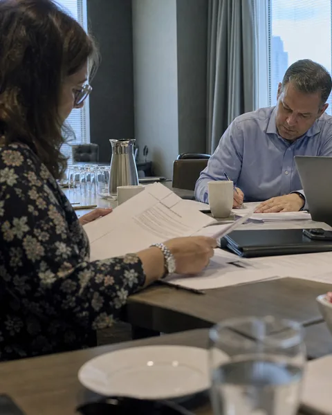 Two business people reading documents during a negotiation